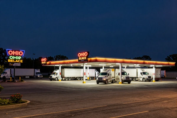 Ohio truck stop parking lot at night with glowing neon signs - trucker dating Ohio routes